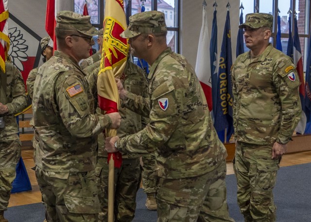 Col. Jesse Chace, right, commander of the U.S. Army Garrion Poland, passes the garrison’s colors to Command Sgt. Maj. Jason Jones, incoming senior enlisted advisor, during the change of responsibility ceremony, Nov. 26, on Camp Kosciuzko,...