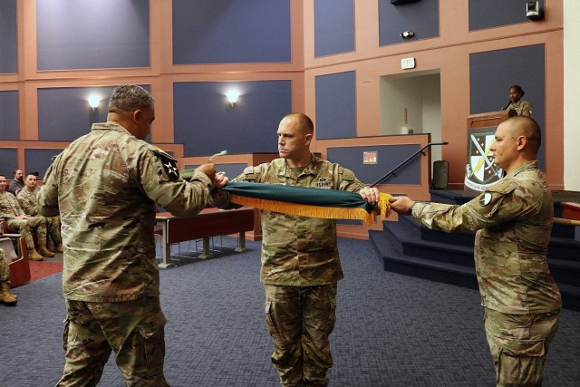 Lt. Col. Matthew Maness, commander of 2nd Battalion (Red Team), 1st Information Operations Command (Land) (center), and battalion Sgt. Maj. Edwin Hernandez (left), case the battalion colors during the ceremony inactivating the unit, at Fort...