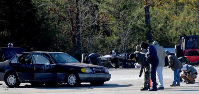 Students study the scene after a car was blown up as part of the Basic Post Blast Investigative Techniques class