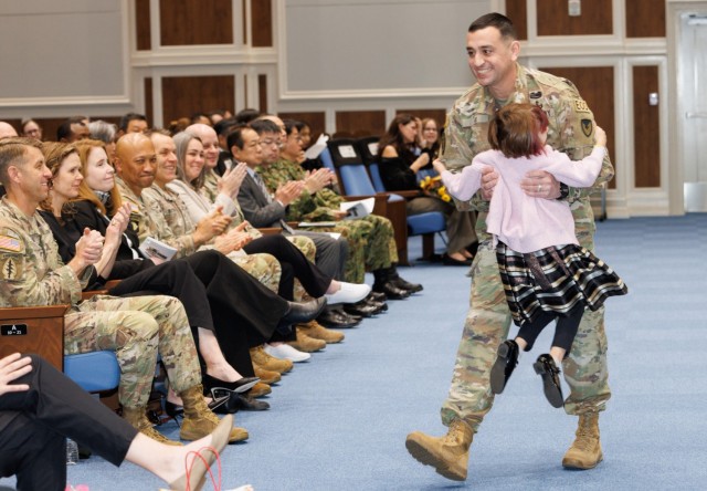 Command Sgt. Maj. David A. Rio hugs his daughter, Evelyn, during his change of responsibility ceremony at Camp Zama, Japan, Dec. 12, 2024. Command Sgt. Maj. Rick Meeker assumed responsibility of U.S. Army Garrison Japan&#39;s senior enlisted leader role from Rio, who plans to take a position at Fort Gregg-Adams, Virginia.
