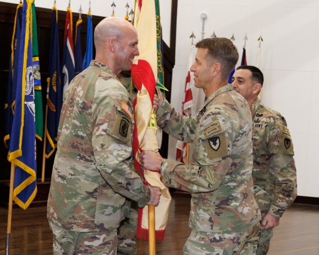 Col. Marcus Hunter, right, commander of U.S. Army Garrison Japan, passes the garrison&#39;s guidon to Command Sgt. Maj. Rick Meeker, who officially assumed the role of the garrison&#39;s senior enlisted leader during a ceremony at Camp Zama, Japan, Dec. 12, 2024. Command Sgt. Maj. David A. Rio, far right, who plans to take a position at Fort Gregg-Adams, Virginia, relinquished responsibility of the role to Meeker. 