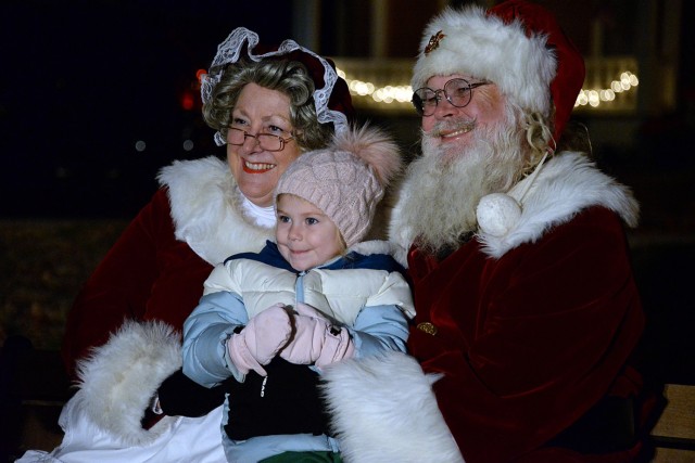 Three-year-old Hudson Zimmer poses for a photo for Hudson’s mom, Jessica Zimmer, with Mrs. Claus and Santa Claus during the annual holiday lighting event Dec. 6, 2024, at Zais Park on Fort Leavenworth, Kansas. Photo by Prudence Siebert/Fort...