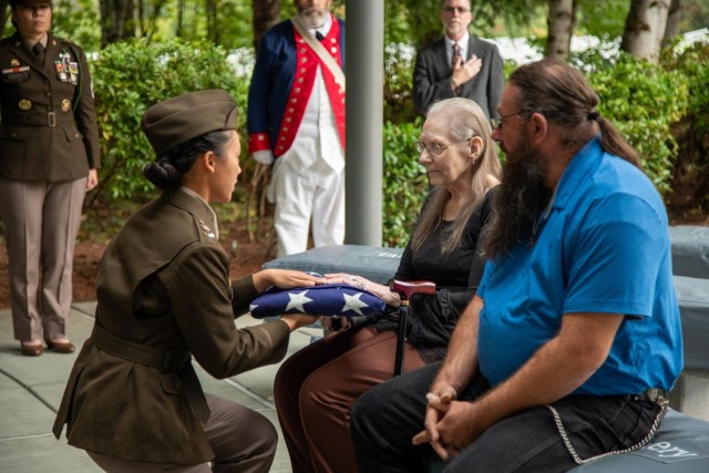 Sister and Nephew of Cpl. Frederic Higgins, Sandy and Tim Naquin, receives a folded American flag from the 7th Infantry Division Honor Guard on Sept. 20. 2024.