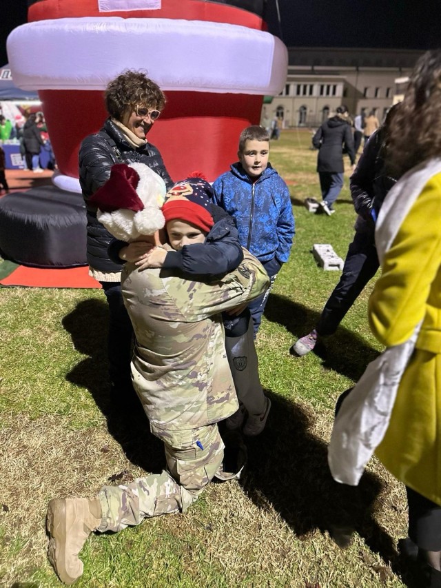 Italian boy asks garrison commander, Col. Scott Horrigan, for hug at garrison tree lighting event Dec. 5.