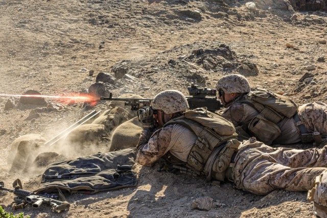 U.S. Marine Corps Lance Cpl. Kashigo Meade, left, and Lance Cpl. Michael Melkonyan, both machine gunners assigned to Charlie Company, Battalion Landing Team 1/5, 15th Marine Expeditionary Unit, fire an M240B machine gun while conducting Range 410A...