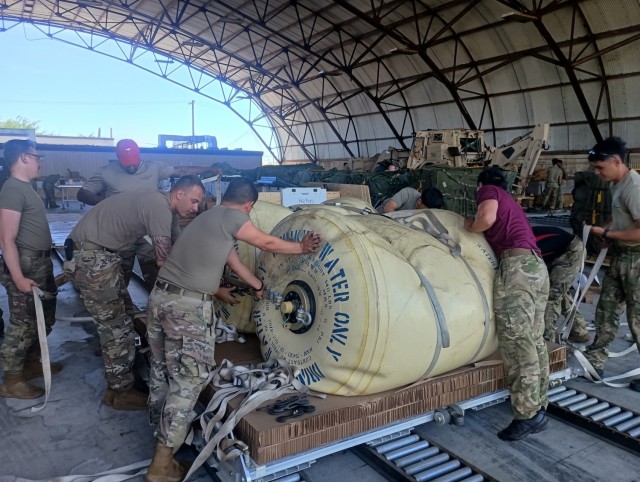 4th Quartermaster Theater Aerial Delivery Company and New Zealand Parachute Riggers prepare an 8-foot Type V airdrop platform using two water blivits during the Joint Pacific Multinational Readiness Center rotation 25-01. at Hickam Airforce Base,...