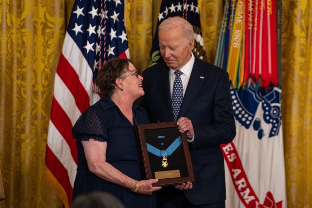 President Joe Biden presents to the Medal of Honor for former Army Capt. Hugh Nelson, to his daughter, Debra Nelson McKnight, during a Medal of Honor ceremony at the White House, Jan. 3, 2025. Nelson – one of seven U.S. Soldiers from the Korean and Vietnam Wars to receive the Medal of Honor at the White House today – was posthumously recognized and honored for his acts of extraordinary heroism in saving the lives of his crew members under enemy fire during the Vietnam War on June 5, 1966, while serving as the aircraft commander of an armed Huey helicopter with the 114th Aviation Company (Airmobile Light), 13th Aviation Battalion, near Moc Hoa, Republic of Vietnam. (U.S. Army photo by Henry Villarama)