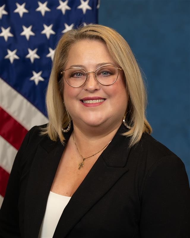 Stacy Matassa with the American flag in the background.