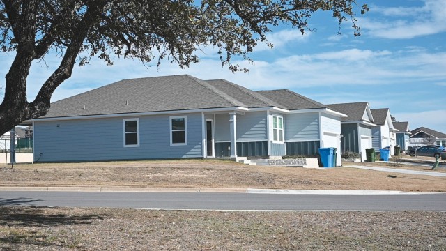 Blue houses with a gray roof sit in a row.