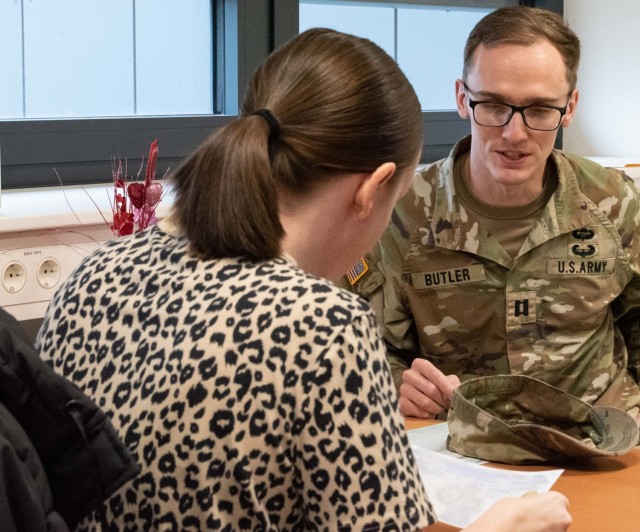 Army Capt. Jack Butler confirms data on his registration form with a staff member at the Wiesbaden Vehicle Registration Office.