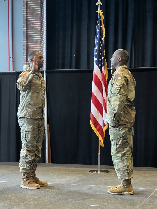 Maj. Guster Cunningham IV, left, recites the oath of commissioned officers as he is sworn in by his father, Maj. Guster Cunningham III, in front of family and friends at West Point, New York, on December 6, 2024.