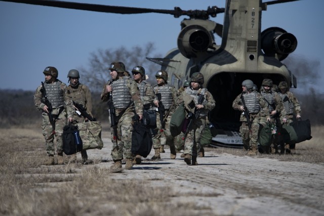 Members of the 221st Combat Communications Squadron depart a Texas Army National Guard CH-47F Chinook belonging to the 149th Aviation Battalion during Exercise FrostByte ACE at Fort Wolters Training Site, Mineral Wells, Texas, Jan. 30, 2025. The nine-day exercise enabled Airmen to train on setting up forward positions in austere locations. (Texas Air National Guard photo by Staff Sgt. Thomas Johns)