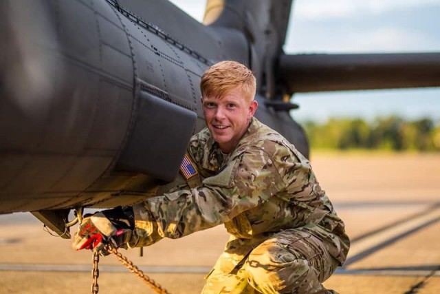 Capt. Phillip C. Fluke performs a preflight check on an AH-64 Apache helicopter. Fluke, a pilot, became an editor for Aviation Digest in 2024 after being selected as a member of the first group of Harding Fellows.