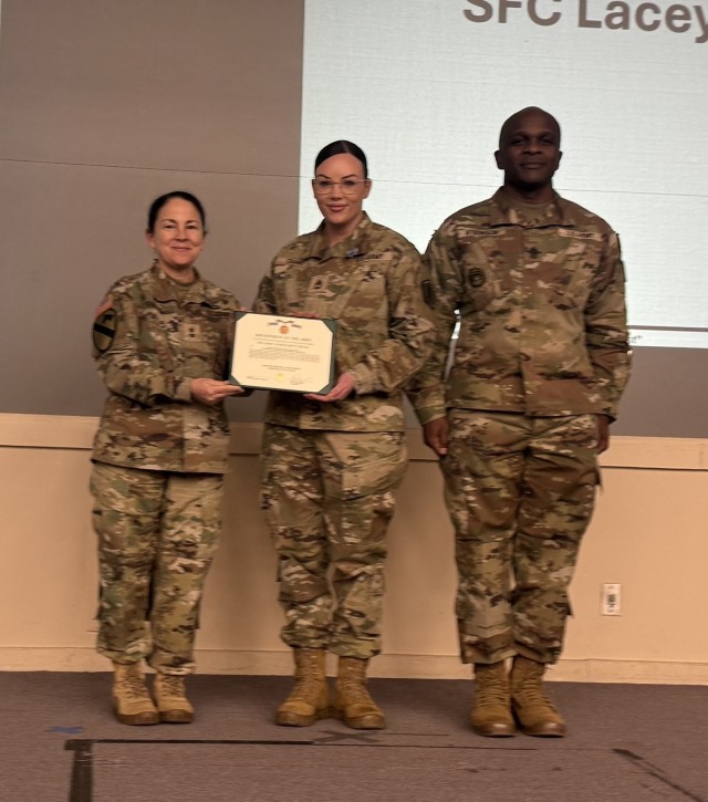 Sgt. First Class Lacey Evans receives an Army Accommodation Medal from Maj. Gen Hope Rampy, commanding general of the U.S. Army Human Resources Command, and Command Sgt. Maj. Robert Atkinson, enlisted advisor at an HRC All Hands Meeting for...
