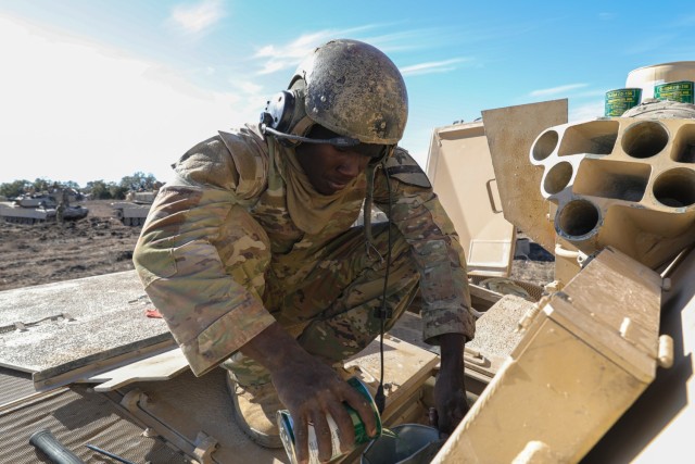 Spc. Justice Adams, assigned to 1-12 1st Battalion, 12th Cavalry Regiment, 3rd Brigade Combat Team, conducts preventive maintenance checks and services on a M1A3 Abrams Main Battle Tank after their Combined Arms Live Fire Exercise (CALFX)...