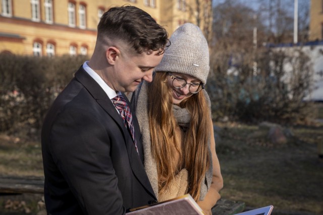 Billie Endress, left, an operations specialist with U.S. Army Garrison Poland, and Aniela Endress, right, a former Army Polish nurse, revisit their wedding album while sitting on the same bench where they had their first date five years ago. The...