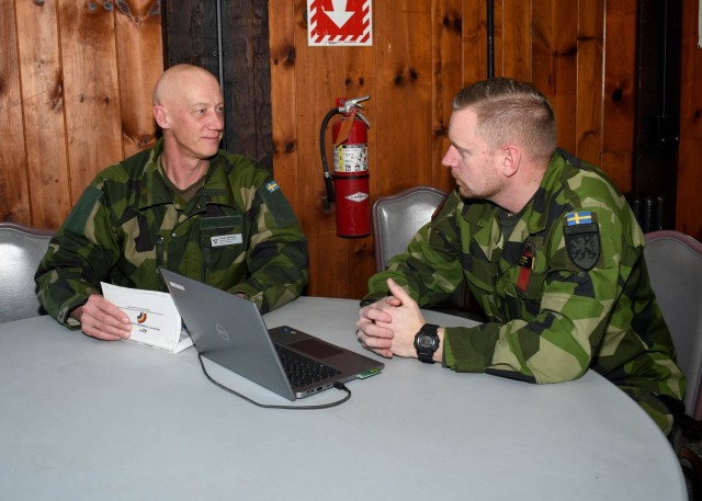 FORT INDIANTOWN GAP, Pa. – Swedish Army Lt. Col. Lt. Col. Fredrik Mansson (left), the chief of operations for the 1st Division Headquarters, speaks with Swedish Army Lt. Col. Jesper Sparre about 42nd Infantry Division command post procedures during the 42nd Inf. Div.’s Warfighter 25-3 exercise at Fort Indiantown Gap, Pa., Jan. 31, 2025.  The Swedish soldiers’ participation with the New York Army National Guardsmen during Warfighter Exercise 25-3 marks their second visit with the 42nd Inf. Div., and their first experience working with the U.S. in a division-level warfighter exercise. 