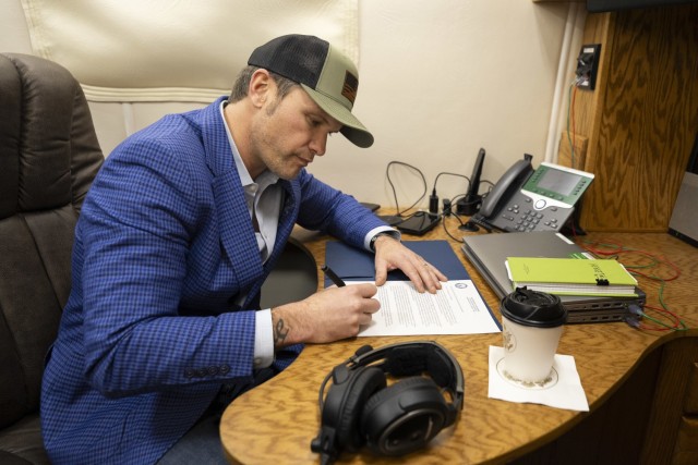 Secretary of Defense Pete Hegseth signs a memorandum reversing the name of Fort Liberty back to Fort Bragg while flying in a C-17 operated by the 300th Airlift Squadron en route to Stuttgart, Germany, Feb. 10, 2025.