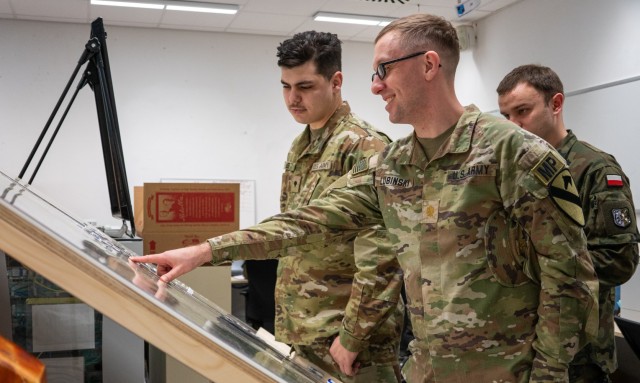 Maj. Michael Lubinski, deputy provost marshal of the 1st Cavalry Division, looks over a map of the local area with a Soldier and a Polish counterpart from 11th Armored Cavalry Division, during Exercise Combined Resolve 25-1 at the Joint Multinational Readiness Center on Hohenfels Training Area, Germany, Jan. 29, 2025. Approximately 4,000 military personnel from the U.S. and 15 European countries are participating in Combined Resolve 25-1. (U.S. Army photo by Sgt. Jacob Nunnenkamp)