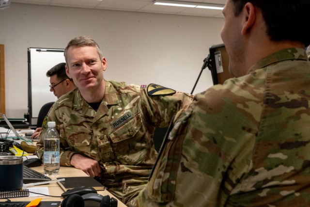 British Army Maj. Scott Russell, 1st Cavalry Division chief of operations, speaks with a fellow Soldier during Exercise Combined Resolve 25-1 at the Joint Multinational Readiness Center on Hohenfels Training Area, Germany, Jan. 29, 2025. During Combined Resolve 25-1, the U.S. Army is implementing its Transforming in Contact initiative, utilizing new technologies and systems designed to enhance its warfighting readiness and ability to respond to crisis or conflict. (U.S. Army photo by Sgt. Jacob Nunnenkamp)