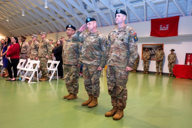 Col. Mark Glaspell (center), 1st Engineer Brigade commander, salutes the ceremonial commander of troops before he and outgoing Command Sgt. Maj. Don Batchan (left) and incoming Command Sgt. Maj. Jesse Cody (right) march forward to conduct a...