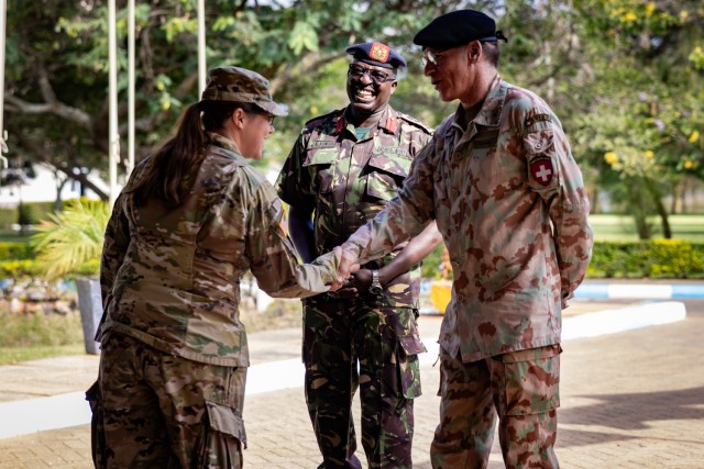 U.S. Army Lt. Col. Trish Basile, Chief of the Kenya United States Liaison Office (KUSLO), and Col. Jonathan Rungwe, Commandant of the Humanitarian Peace Support School (HPSS), welcome a Swiss service member with a handshake during the opening...