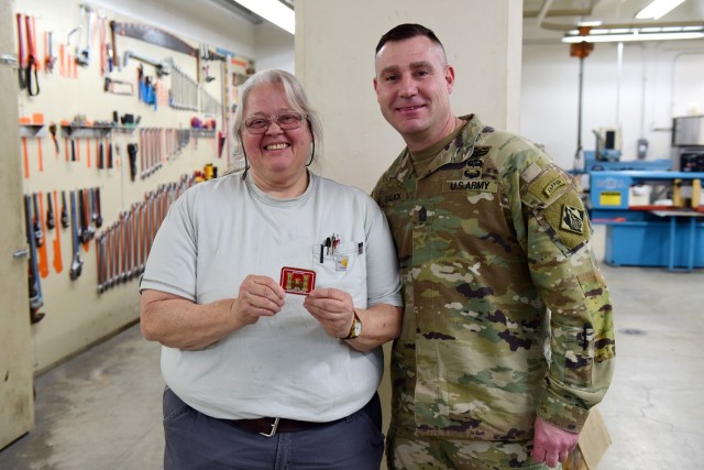 U.S. Army Corps of Engineers Command Sgt. Maj. Douglas Galick presents Deborah Greene, journeyman mechanic at the Wolf Creek Dam Powerhouse, with a coin recognizing excellence during a visit Feb. 11, 2025, to the project on the Cumberland River in...