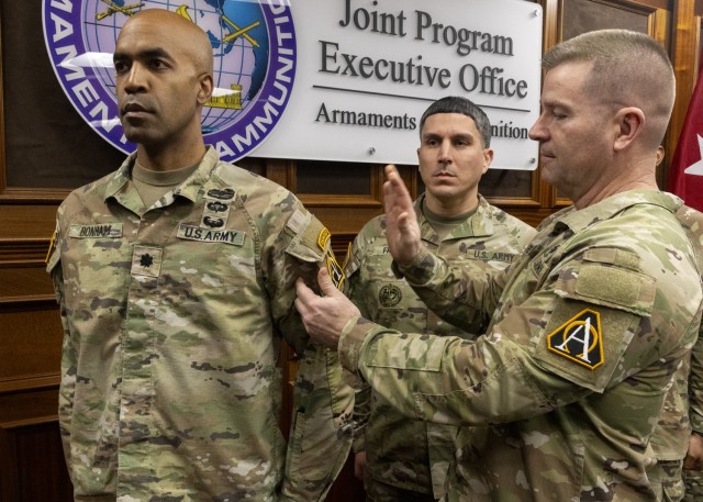 PICATINNY ARSENAL, N.J. - Maj. Gen. John T. Reim, Picatinny Arsenal commanding general and Joint Program Executive Officer Armaments and Ammunition (far right) affixes the Assistant Secretary of the Army (Acquisition, Logistics and Technology) or...