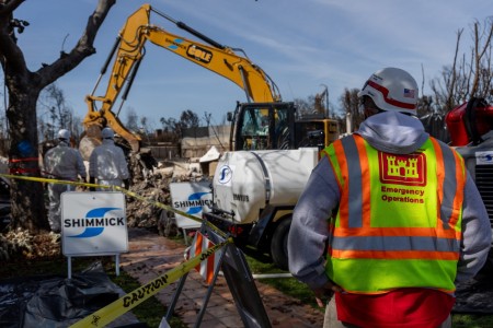 A U.S. Army Corps of Engineers quality assurance specialist observes debris removal efforts at a residential property in Pacific Palisades, Calif., on February 15, 2025. This property is the first in the area to have debris cleared following the January 2025 wildfires. The Corps is supporting FEMA and local agencies in the removal of hazardous materials and structural debris to facilitate community recovery. (U.S. Army Corps of Engineers photo by Travis England)