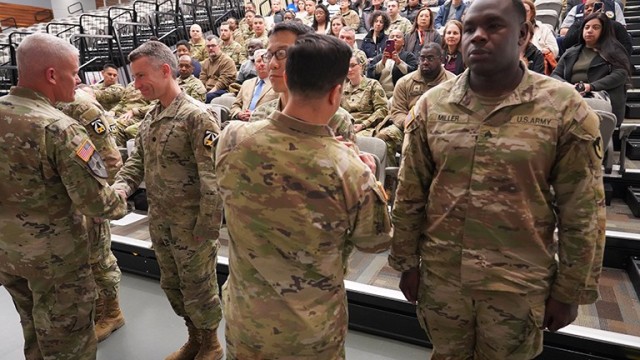 Col. Christopher Chung, commander, U.S. Army Garrison Fort Detrick, affixes the Army Futures Command patch on the sleeves of garrison Soldiers during a ceremony, Feb. 19, 2025.