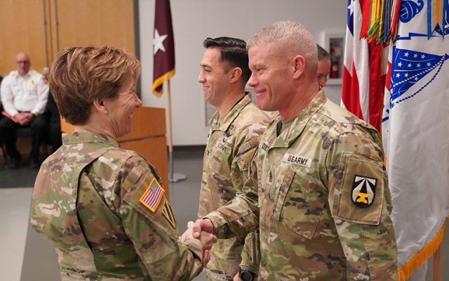 Maj. Gen. Paula C. Lodi, commander, U.S. Army Medical Research and Development Command, shakes hands with U.S. Army Garrison Fort Detrick Command Sgt. Maj. Erick Detrich during a &#34;patch&#34; ceremony, Feb. 19, 2025.