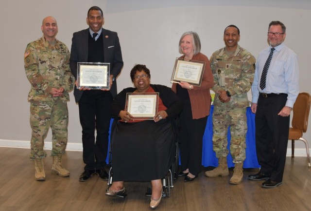 Col. David Stewart, Garrison Commander (left) poses with his command team, Command Sgt. Maj. Reginald Smith, Headquarters Battalion Command Sergeant Major and Mr. Sean Lehane, Deputy Garrison Commander (right), pose with the recipients of the Good...