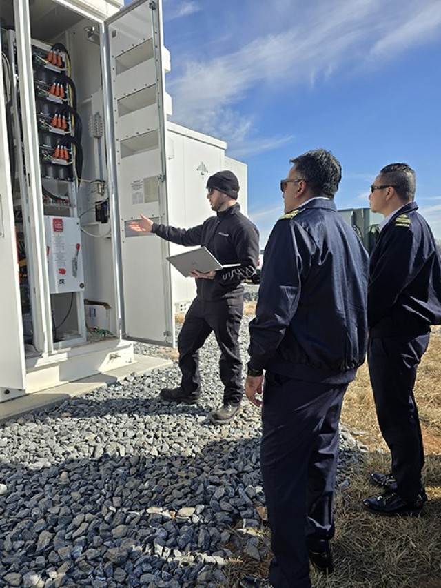 A technician explains how Fort Detrick’s BESS system operates to members of the Singapore Armed Forces.