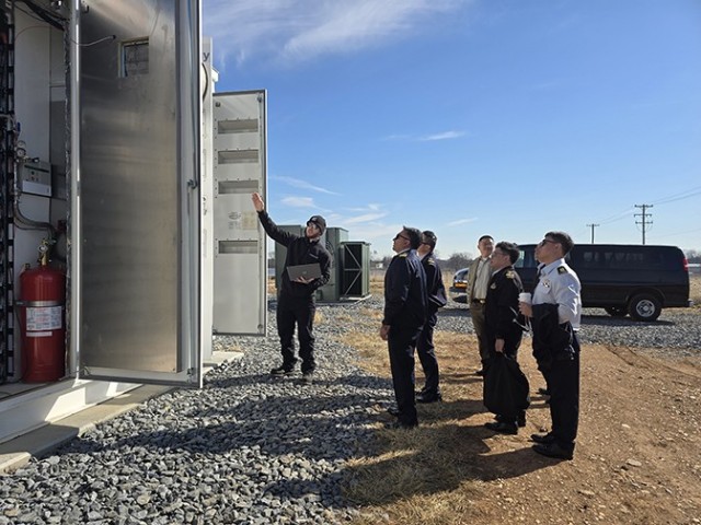A technician explains how Fort Detrick’s BESS system operates to members of the Singapore Armed Forces.