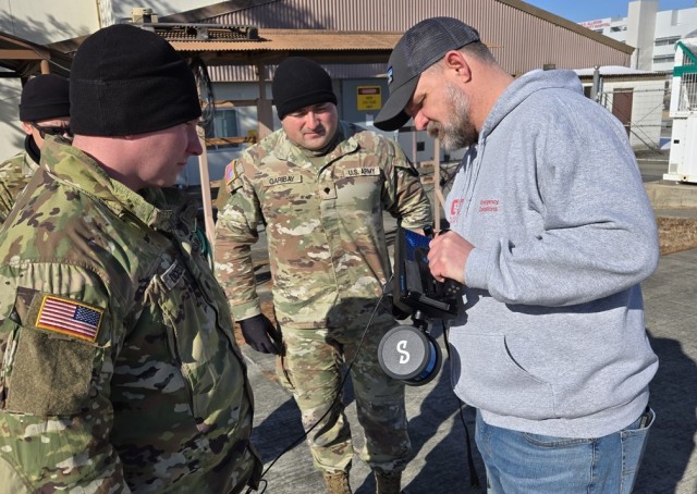 Engineer and Soldiers examine reconnaissance equipment.
