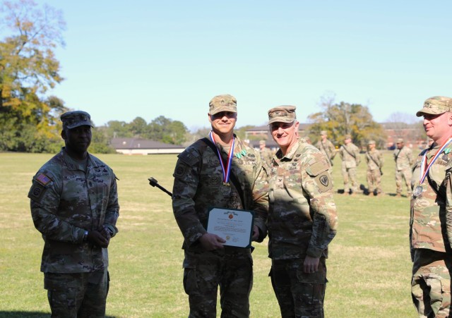 Staff Sgt. Jared Lollar, 128th Aviation Brigade, Joint Base Langley-Eustis, Va., receives a certificate presented by Col. Clint Cody, U.S. Army Aviation Center of Excellence chief of staff and Command Sgt. Maj. Kirk Coley, Aviation branch command...