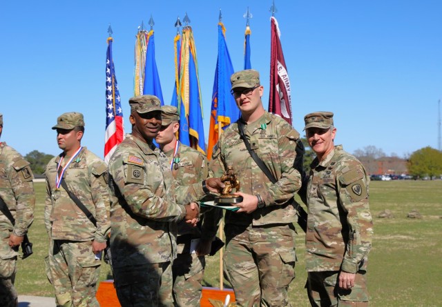 Pfc. Cody Voyles, 110th Aviation Brigade, receives a trophy presented by Col. Clint Cody, U.S. Army Aviation Center of Excellence chief of staff and Command Sgt. Maj. Kirk Coley, Aviation branch command sergeant major, for being named the AVCOE...