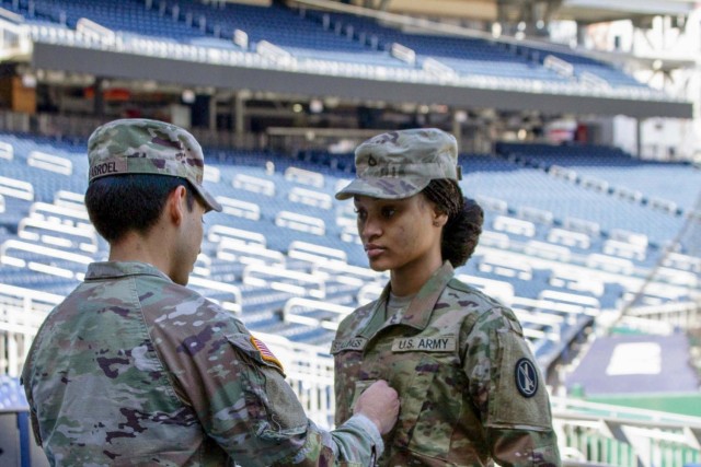 Army Sgt. Alex Villarroel pins Ariyana Stallings to the rank of specialist inside the Washington Nationals Stadium on March 7.