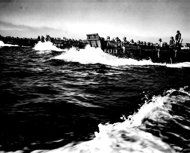 A line of Coast Guard landing barges, sweeping through the waters of Lingayen Gulf, carries the first wave of invaders to the beaches of Luzon, after a terrific naval bombardment of Japanese shore positions on Jan. 9, 1945. (Courtesy Photo)