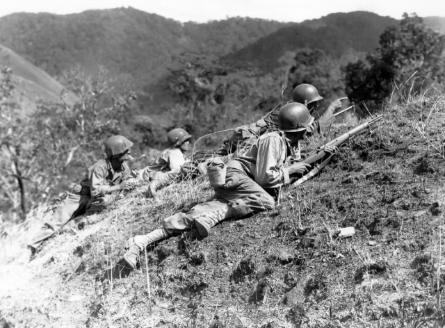 A squad leader points out a suspected Japanese position where troops of the 25th Infantry Division are in fierce combat with Japanese forces at the edge of Balete Pass, near Baguio, on March 23, 1945. (Courtesy Photo)