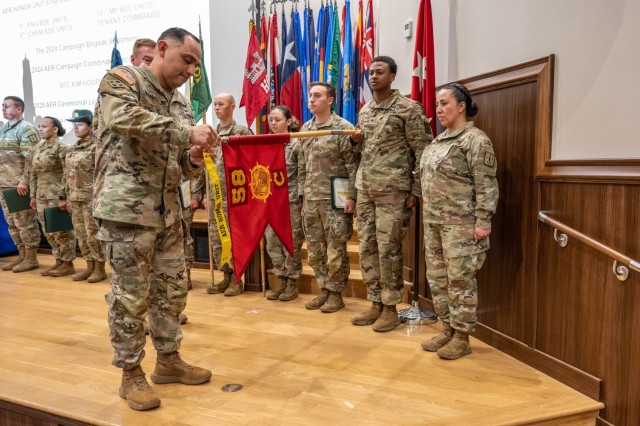 Maneuver Support Center of Excellence and Fort Leonard Wood Command Sgt. Maj. Jorge Arzabala attaches an Army Emergency Relief, or AER, Honor Unit streamer to the Company C, 58th Transportation Battalion’s unit colors, during a ceremony held...