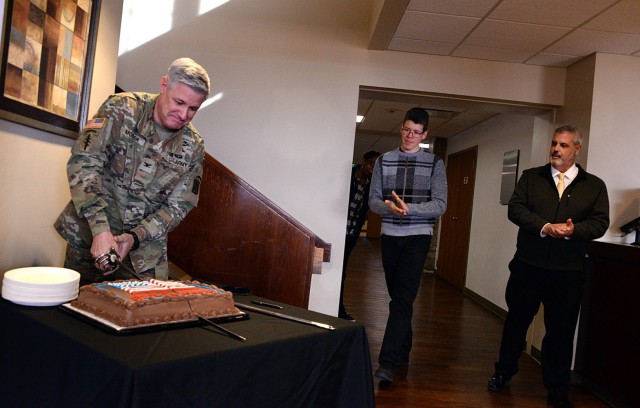 Fort Leavenworth Garrison Commander Col. Duane Mosier cuts a cake to signify the launch of the 2025 Army Emergency Relief Campaign as Zach Stephens, Family and Morale, Welfare and Recreation special events coordinator, and Paul Martocci,...