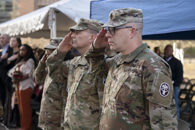 Outgoing Command Sgt. Maj. Dedraf Blash, Col. Mark Stackle, Brooke Army Medical Center commander, and Command Sgt. Maj. Jan “Eddy” Miller render a salute during a change of responsibility ceremony outside BAMC, Joint Base San Antonio – Fort...