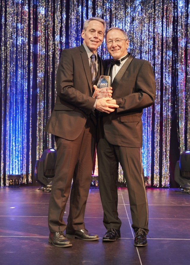 Ron Ziegler, AACT Festival coordinator presents Jerry Brees, Soldiers&#39; Theatre Director, left, the AACT David C. Bryant Outstanding Service Award during the 2018 TOPPERs Awards ceremony in Wiesbaden, Germany.