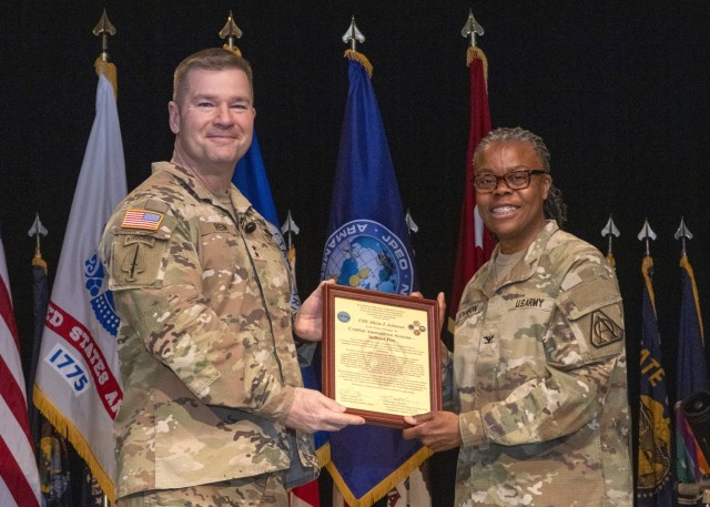 Maj. Gen. John T. Reim, Joint Program Executive Officer for Armaments & Ammunition, presents Col. Alicia Johnson with the Charter of Project Manager of Combat Ammunition Systems.