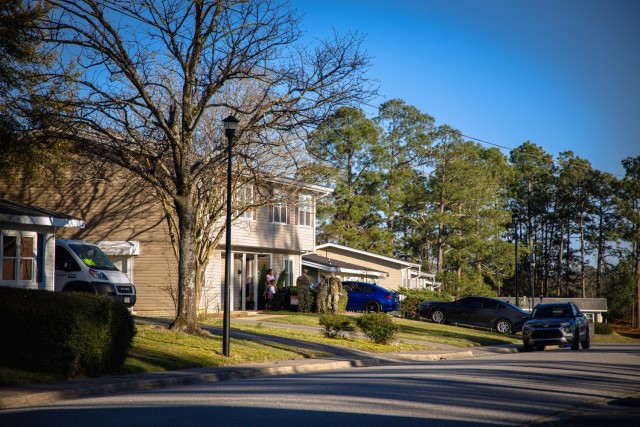 Representatives from Dwight D. Eisenhower Army Medical Center engage with a family at their home's front entrance during the Walking Town Hall on March 17, 2025, in Azalea Terrace. The event provided an opportunity for residents to learn about...