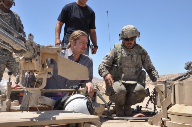 Actor Brad Pitt, speaks with a tank crew Soldier during a 2013 visit to Fort Irwin, Calif. in preparation for the film "Fury."