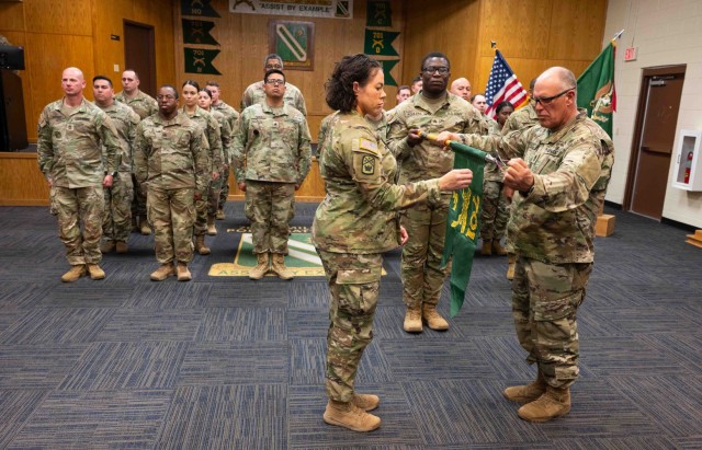 Capt. Natasha Price, commander of Company F, 701st Military Police Battalion, and 1st Sgt. Bryan Niemiec uncase their company’s guidon during an activation and assumption-of-command ceremony March 7 at the battalion’s headquarters. The...