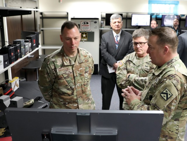 Air Force Lt. Gen. Dagvin Anderson and Combined Arms Center-Training Deputy Commanding General Brig. Gen. Jeremy Wilson listen to Staff Sgt. Bryan Davis explain the marksmanship training technology currently being evaluated at the Combined Arms...