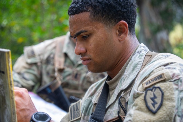 A U.S. Army Soldier assigned to the 25th Infantry Division inspects the plot location during a land navigation training in preparation for the Expert Infantry, Expert Soldier, and Expert Field Medical Badges (E3B) on Schofield Barracks, Hawaii,...